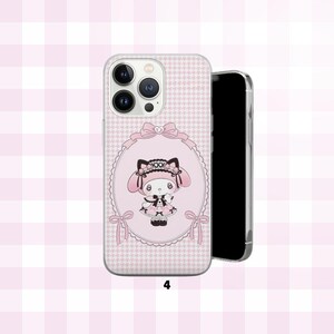 May include: A pink phone case with a cartoon character in a pink oval frame and bows. The case has a houndstooth pattern and the number "4" at the bottom. The phone case is next to a black phone.