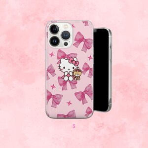 Puede incluir: Funda de tel&eacute;fono rosa con dise&ntilde;o de Hello Kitty, lazos y estrellas. La funda tiene un borde transparente y se ve un tel&eacute;fono negro en el interior. El dise&ntilde;o incluye un personaje de dibujos animados de Hello Kitty y un peque&ntilde;o oso de peluche.