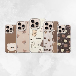 Könnte beinhalten: Fünf Handyhüllen mit Bärenmotiven in Braun- und Cremetönen. Die Hüllen zeigen Bärenillustrationen, Pfotenabdrücke und die Texte "happy" und "Hi~ bear". Die Designs variieren und bieten eine Reihe von Stilen.