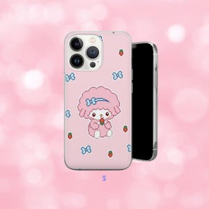 May include: Pink phone case featuring a cartoon character with a blue bow and holding a strawberry. The case has a pixelated design with blue bows and strawberries scattered across the surface. A black smartphone is next to the case.