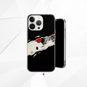 May include: Black phone case with a torn paper design revealing a cartoon illustration of a girl with red bows and eyes. A second phone is shown next to the case.