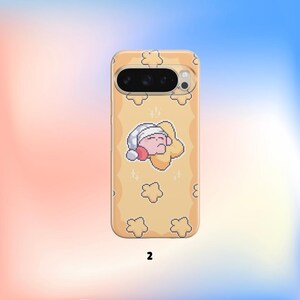 Pu&ograve; includere: Custodia per telefono giallo chiaro con un design pixelato raffigurante un personaggio addormentato su una nuvola, con cuffia da notte. Motivi di stelle e nuvole. Il numero "2" &egrave; stampato in basso.