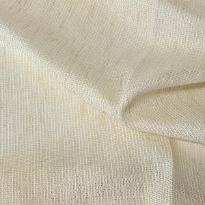 Pode incluir: Um tecido de cor marfim com uma textura vis&iacute;vel, grossa e de trama aberta. O material est&aacute; drapeado em dobras suaves, criando sombras e reflexos naturais na superf&iacute;cie. A palavra "Ivory" est&aacute; impressa em texto preto sobre o tecido.