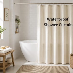 May include: A neutral-toned waterproof shower curtain hangs in a bright bathroom. The text "Waterproof Shower Curtain" is printed on the curtain. The bathroom features a white bathtub, a wooden bench with towels, and a woven rug.
