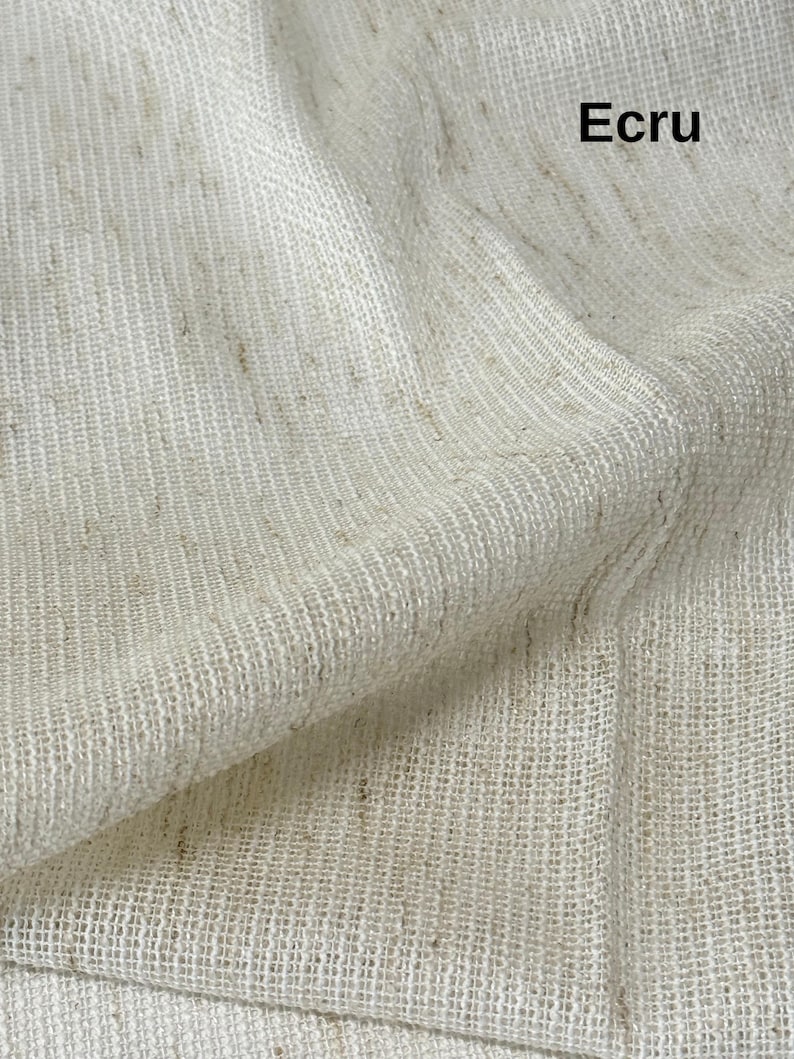 Pode incluir: Uma pe&ccedil;a de tecido na cor crua com uma textura tecida vis&iacute;vel e um padr&atilde;o de trama aberta e solta. O material apresenta manchas sutis de marrom claro por toda a superf&iacute;cie esbranqui&ccedil;ada. A palavra Ecru est&aacute; impressa em preto no canto.