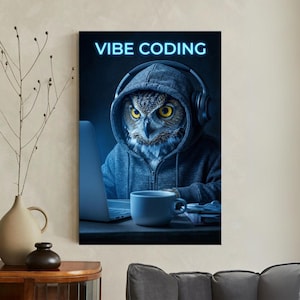 May include: A canvas print featuring an owl wearing a gray hoodie and headphones, working on a laptop. The text "VIBE CODING" is displayed above the owl in a neon blue font. A white mug sits on the desk.