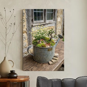 May include: A galvanized metal watering can transformed into a miniature garden. It features a bonsai tree, small white flowers, and moss. The can sits on a wooden surface with stone steps, creating a charming, rustic display.