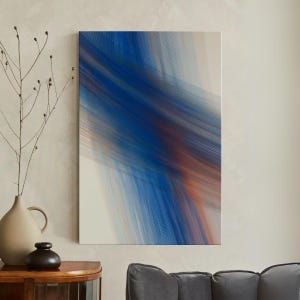 May include: Abstract art print with a dynamic composition of blue and orange lines against a white background. The artwork is displayed on a wall, adding a modern touch to the room's decor. The piece is a rectangular canvas.