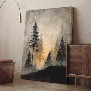 Könnte beinhalten: Leinwanddruck mit einer nebligen Waldszene mit hohen, dunklen Nadelbäumen. Das Kunstwerk verwendet eine gedämpfte Farbpalette aus Grau, Schwarz und Gold und schafft eine ruhige Landschaft. Der Druck lehnt an einer Wand und zeigt seine Größe und Textur.