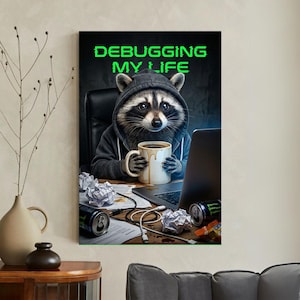 Può includere: Stampa incorniciata con un procione con cappuccio che tiene una tazza di caffè e lavora su un laptop. Il testo verde "DEBUGGING MY LIFE" è presente. La scena include carta stropicciata, lattine di energy drink e cavi.