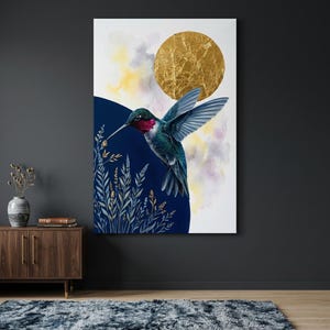 Puede incluir: Impresión en lienzo que representa un colibrí en vuelo. El ave tiene plumas azules y verdes iridiscentes, una garganta roja y un pico largo. Un sol de pan de oro y un semicírculo azul oscuro están en el fondo, con nubes de acuarela.