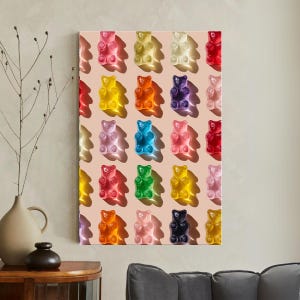 May include: A canvas print featuring a grid of colorful gummy bear candies. The bears are in various colors, including red, yellow, orange, purple, blue, and pink, against a light pink background. The image is well-lit, with shadows.