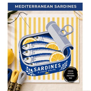 Op de afbeelding: Een kruissteekpatroon met een open blauw sardineblikje met citroenschijfjes op een geel en wit gestreepte achtergrond. De tekst luidt MEDITERRANEAN SARDINES en SARDINES A L'HUILE D'OLIVE. Inclusief een zwart rond label met witte tekst.