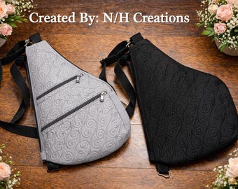 May include: Two sling bags, one light gray and one black, with a quilted swirl pattern. Each bag has three zippered pockets and a black adjustable strap. The bags are displayed on a wooden surface.