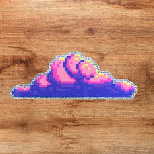 May include: A pixel art sticker of a cloud featuring a dark blue base with vibrant pink and yellow highlights. The sticker has a distinct holographic glitter border that outlines the cloud shape, creating a shimmering effect against the surface.
