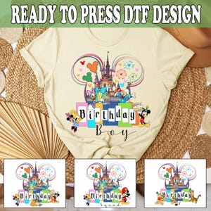 May include: A ready-to-press iron-on transfer design featuring a cartoon illustration of Mickey Mouse's head with the iconic Disney castle and fireworks. The design includes the words "Birthday Boy" in colorful blocks.