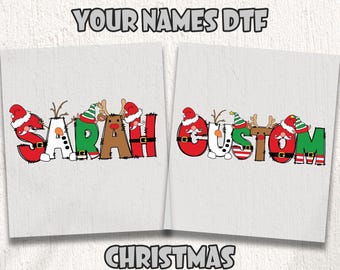 May include: Two white DTF transfer sheets with Christmas-themed designs. One sheet spells "SARAH" and the other spells "CUSTOM", each letter decorated with Santa hats, reindeer antlers, and elf hats. Text at the top reads "READY TO PRESS DTF TRANSFER" and "YOUR NAMES DTF".