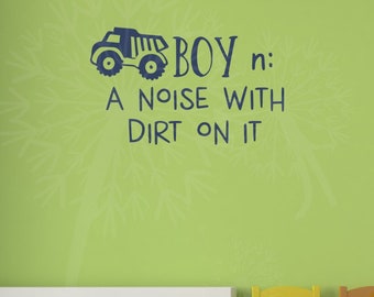 May include: A blue dump truck graphic with the text "BOY: A NOISE WITH DIRT ON IT" on a light green wall.