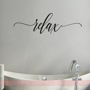 May include: A white bathtub with a silver faucet and the word "relax" written in black cursive on the wall above the tub.