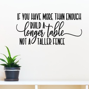 May include: Black and white wall decal with the quote "If you have more than enough build a longer table not a taller fence."