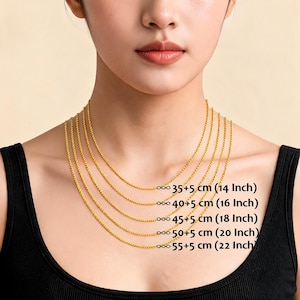 May include: A woman wearing a black top with multiple gold-colored chain necklaces of varying lengths. The necklaces are labeled with their lengths in centimeters and inches: 14, 16, 18, 20, and 22 inches.