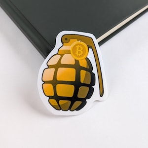 May include: A white sticker with a yellow and black cartoon grenade with a gold coin attached to the pin. The coin has a 'B' symbol on it.