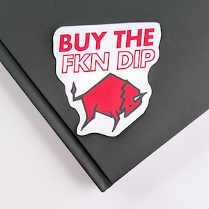 May include: White sticker with red text that says "BUY THE FKN DIP" and a red bull illustration.