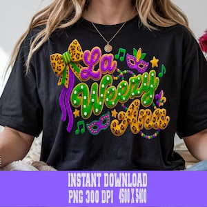 Puede incluir: Camiseta negra con un diseño colorido de Mardi Gras. El diseño incluye las palabras "La Weezzy Ana" en morado, verde y dorado, junto con notas musicales, máscaras y un lazo. La camiseta es una descarga digital.
