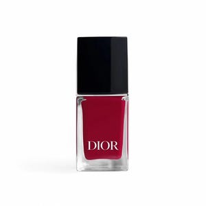 May include: A bottle of red nail polish with a black cap. The clear glass bottle has a rectangular shape and the word "DIOR" is printed in white on the front.