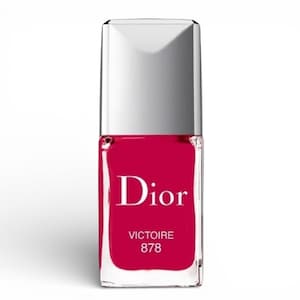 May include: A bottle of Dior nail polish in a vibrant shade of red. The bottle has a rectangular shape with a silver cap. The word "Dior" is prominently displayed on the front, along with "VICTOIRE 878".