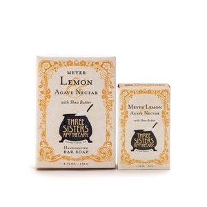 May include: Two boxes of Meyer Lemon & Agave Nectar handcrafted bar soap by Three Sisters Apothecary. The larger box is 4.75 ounces and the smaller box is 1.75 ounces.