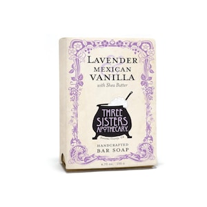 May include: A rectangular bar soap package with a purple floral design and the words "Lavender Mexican Vanilla with Shea Butter." The package also features a black cauldron graphic and the text "Three Sisters Apothecary." The soap weighs 4.75 oz.