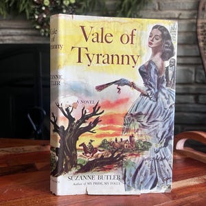 May include: A vintage paperback novel titled "Vale of Tyranny" by Suzanne Butler. The cover art features a woman in a blue gown, a landscape with a rider on horseback, and the title in large, bold letters against a yellow background.