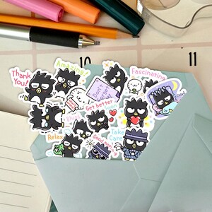 May include: A collection of black and white cartoon stickers featuring a character with a black and white face and a black body. The stickers have various phrases on them, including "Thank You!" "Amazing!" "Don't Forget!" "Get Better Soon" "Fascinating" "Good Morning" "Take Care" "Relax" "Blush" and "Good Night".