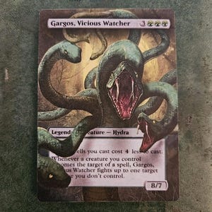May include: A green and black fantasy creature card with the text "Gargos, Vicious Watcher" and "Legend Creature - Hydra". The card has a green and black background with a picture of a multi-headed hydra.