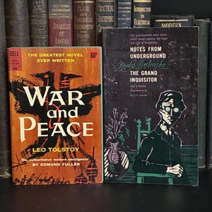 May include: Two paperback books standing upright. The left book is orange with black abstract art and the text War and Peace by Leo Tolstoy. The right book is dark purple with a black and white illustration of a person and the text Notes from Underground and The Grand Inquisitor by Fyodor Dostoevsky.