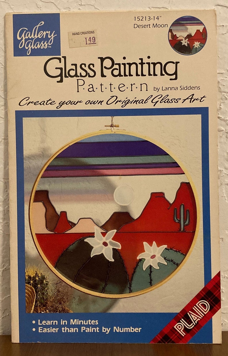 Peut inclure: Patron de peinture sur verre pour une sc&egrave;ne de lune du d&eacute;sert. Le motif repr&eacute;sente un coucher de soleil rouge, orange et bleu sur un paysage d&eacute;sertique avec des cactus et des fleurs blanches. Le motif est dans un cercle de 35,5 cm. Le motif est de Lanna Siddens et est de Plaid.