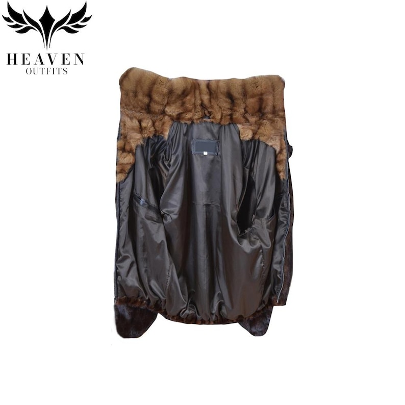 May include: A dark brown jacket with a fur collar and trim. The jacket's interior is a dark, shiny fabric, and it has two large pockets. The jacket is displayed against a white background.