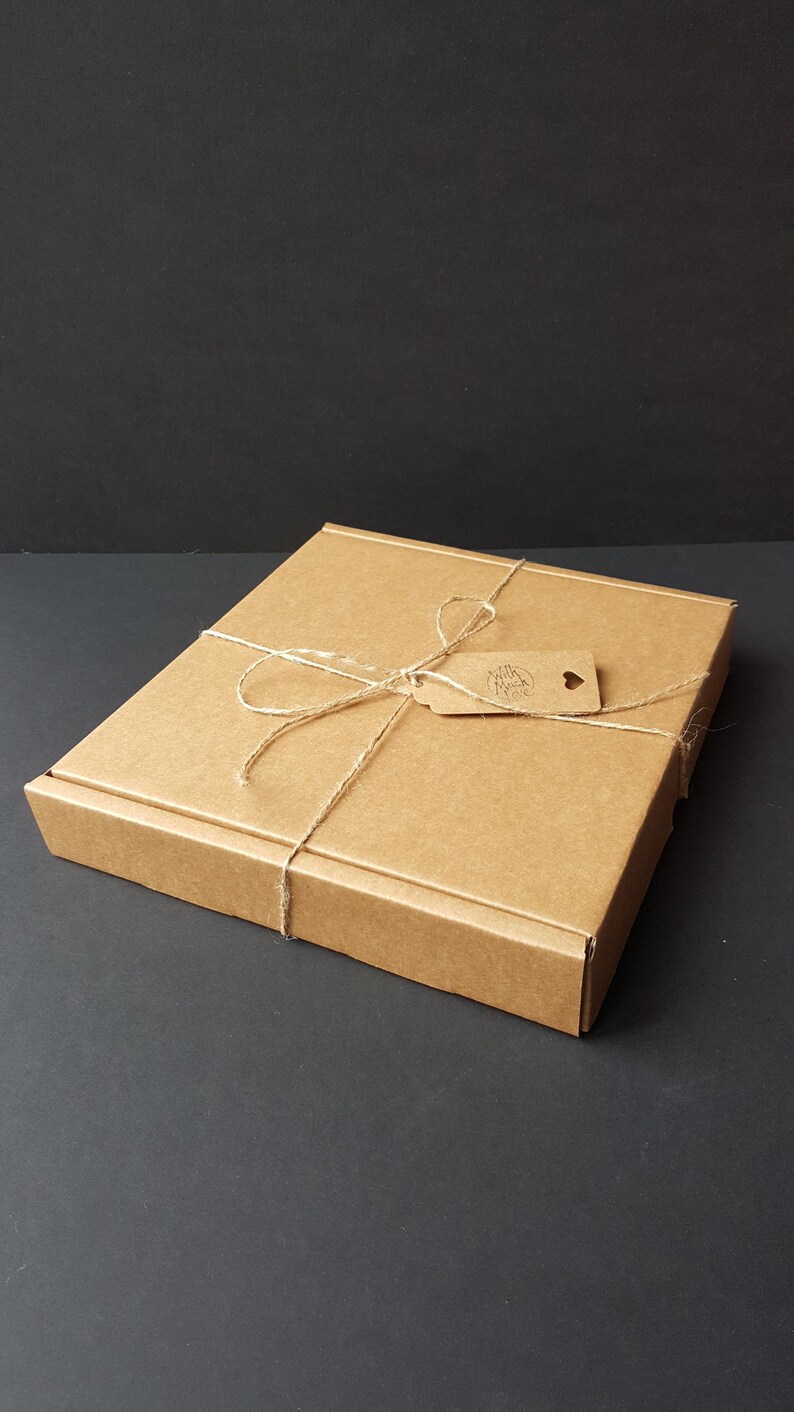 May include: A brown cardboard box with a string tied around it and a small brown tag that says "With Love From" with a heart.