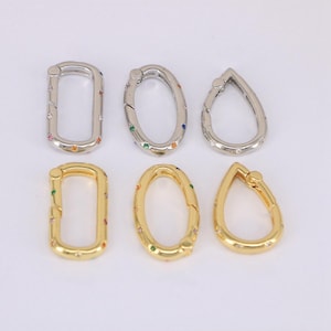 May include: Six metal clasp connectors in silver and gold tones. Each clasp features a different shape: rectangular, oval, and teardrop. The clasps are adorned with colorful, small gemstones. These connectors are suitable for jewelry making.