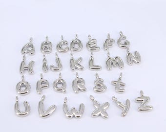 May include: Silver alphabet letter charms, each letter is a separate charm. The letters are in a bubble font style.