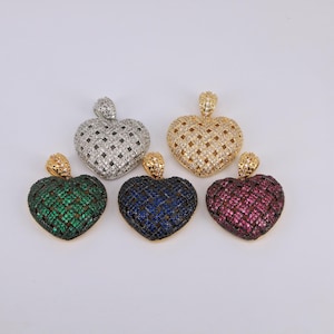 May include: Five heart-shaped pendants with intricate designs. The pendants feature a variety of colors, including silver, gold, green, blue, and red. Each pendant has a small loop at the top for attaching to a chain.