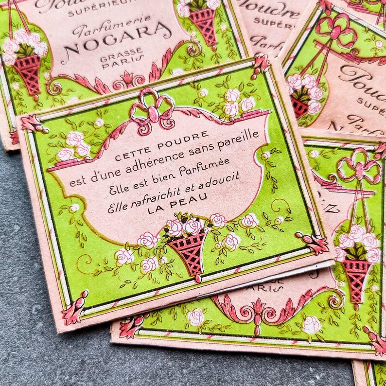 May include: Vintage pink and green powder compact with a floral design and the text "CETTE POUDRE est d'une adh&eacute;rence sans pareille Elle est bien Parfum&eacute;e Elle rafraichit et adoucit LA PEAU".