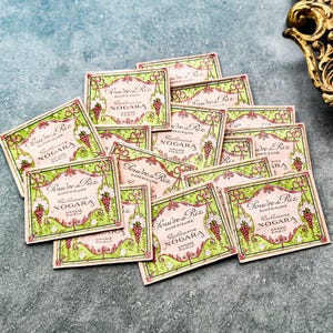 May include: A pile of vintage, green and pink, rectangular, decorative boxes with the text "Poudre de Riz Superieure Parfumerie Nogara Grasse Paris" on each box.