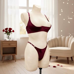 Könnte beinhalten: Weißer Keramikbecher mit schwarzem Henkel und dem Text "But First, Coffee" in schwarzer Schrift. Der Becher steht vor einem verschwommenen Hintergrund, der eine gemütliche Atmosphäre andeutet.