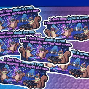 May include: A collection of stickers featuring cartoon squirrels at a rave. The squirrels wear sunglasses and party hats, with text that reads "I don't have ducks in a row. I have squirrels, and they're at a rave."