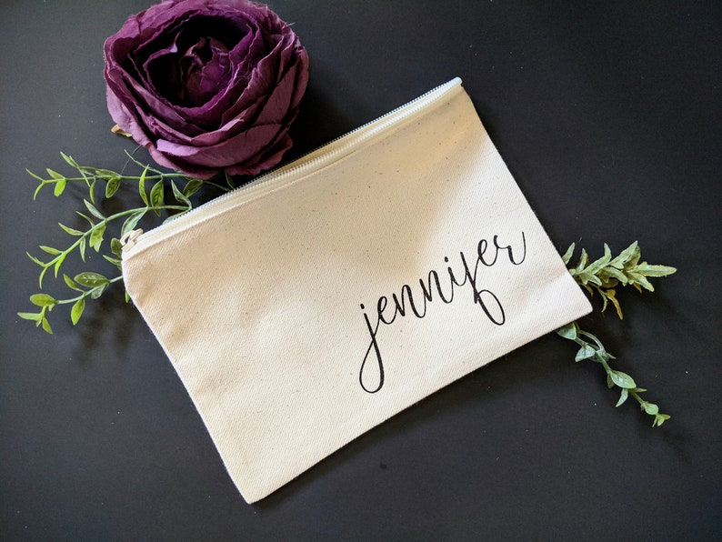 May include: A white canvas zippered pouch with the name "jennifer" written in black cursive script.