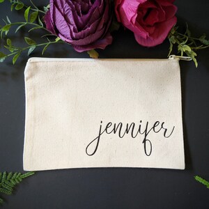 May include: A white canvas zippered pouch with the name "jennifer" written in black cursive script.