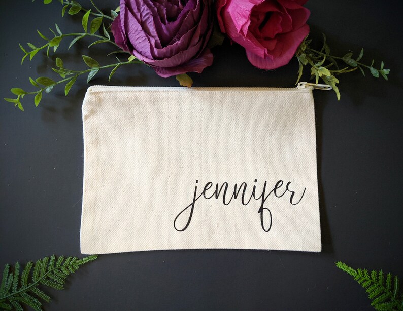 May include: A white canvas zippered pouch with the name "jennifer" written in black cursive script.