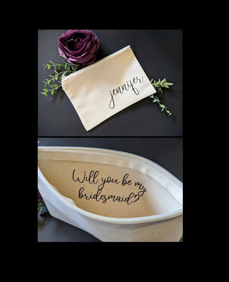 May include: A white canvas zippered pouch with the name "Jennifer" printed on the front. The pouch is open to reveal the text "Will you be my bridesmaid?" printed on the inside.